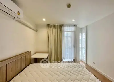 Bright and cozy bedroom with large window and modern furnishings