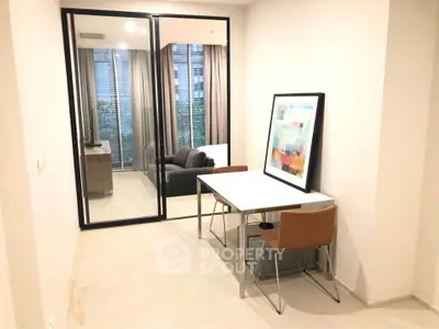 Modern study area with sleek furniture and glass partition in a stylish apartment.