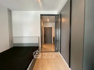 Modern bedroom with sleek design and wooden flooring in a contemporary apartment.