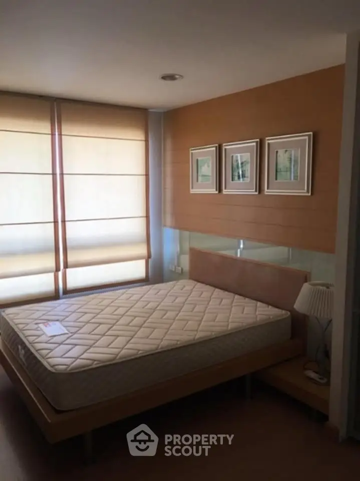 Cozy bedroom with modern decor and natural light, featuring a comfortable bed and stylish wall art.