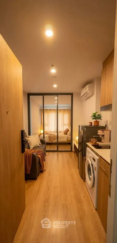 Cozy apartment interior with modern kitchen and living area, featuring wooden flooring and stylish decor.
