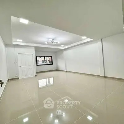 Spacious modern living room with glossy tiled floors and elegant ceiling lights.