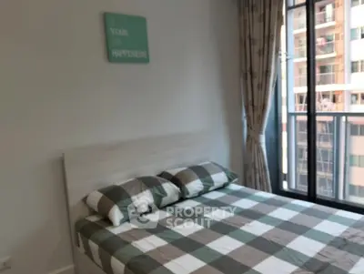 Cozy bedroom with modern decor and city view from large window.