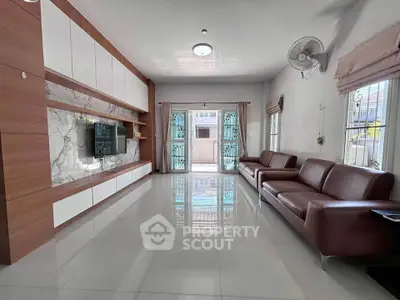 Spacious modern living room with sleek leather sofas and stylish wall unit.