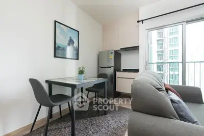 Modern living room with cozy seating and dining area, featuring a compact kitchen and balcony view.