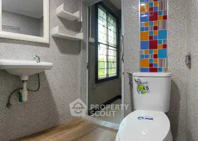 Modern bathroom with colorful tile design and sleek fixtures.