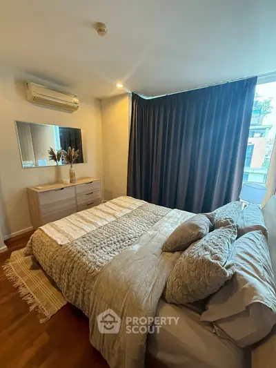 Cozy bedroom with modern decor and large window for natural light