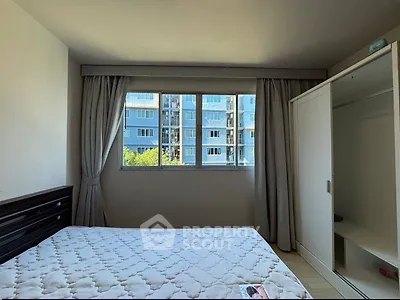 Bright bedroom with large window and modern wardrobe in urban apartment