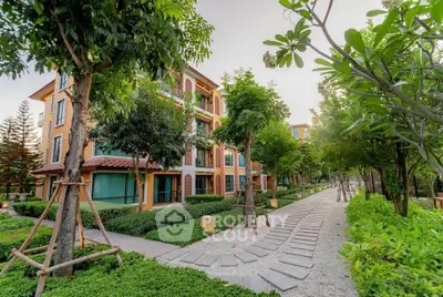 Charming residential building with lush green landscaping and serene walkway