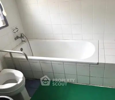 Spacious bathroom with bathtub and modern fixtures, ideal for relaxation.