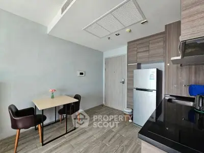 Modern kitchen with sleek appliances and cozy dining area in stylish apartment.