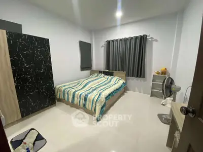 Cozy bedroom with modern decor and ample natural light, featuring a comfortable bed and stylish furnishings.