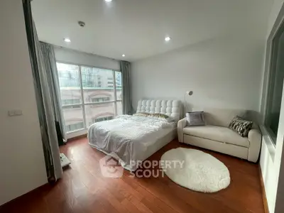 Spacious bedroom with elegant decor and large window view