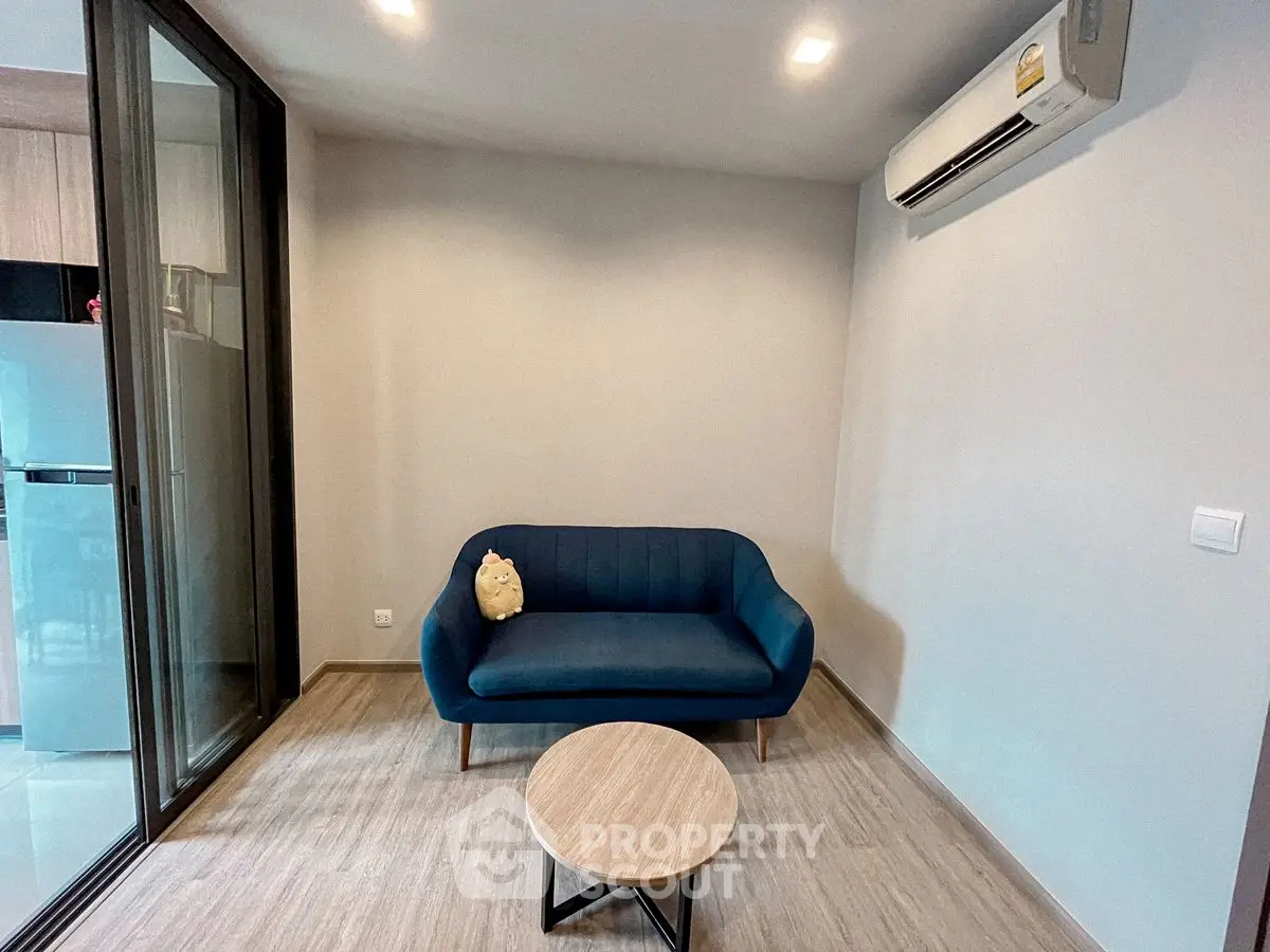 Cozy living room with modern blue sofa and air conditioning