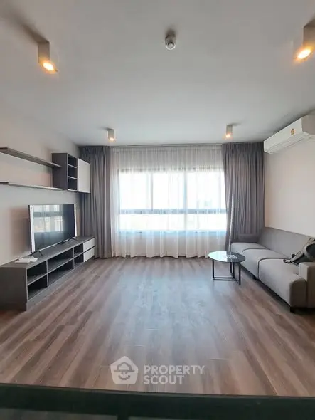 Spacious modern living room with large window and stylish furniture