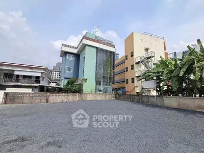 Spacious urban lot with potential for development, surrounded by diverse architecture and lush greenery.