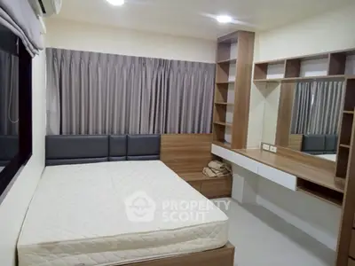 Cozy bedroom with built-in shelves and large window for natural light