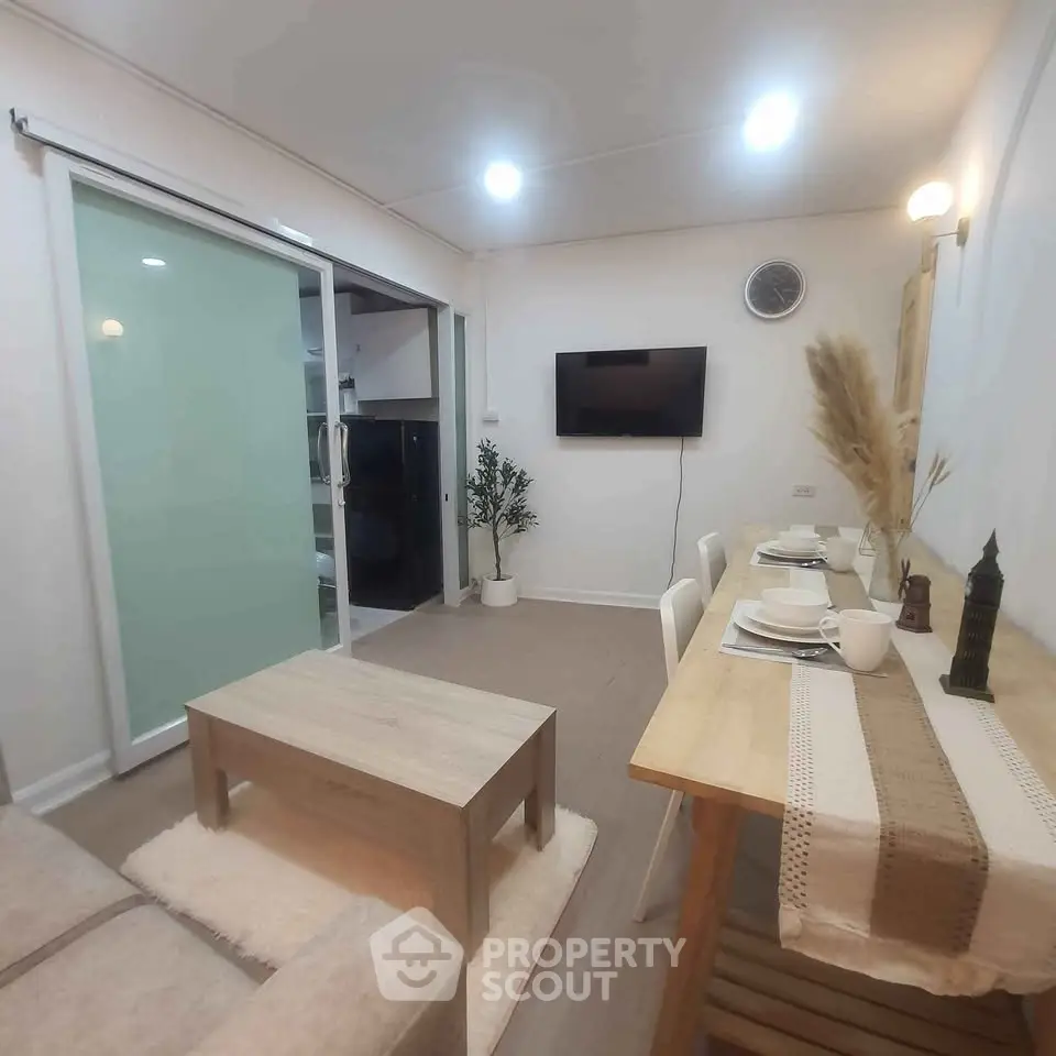 Modern living room with cozy dining area and wall-mounted TV, perfect for entertaining.