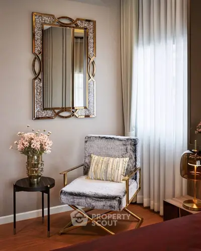 Elegant living room corner with plush chair, decorative mirror, and soft lighting.