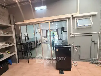 Modern kitchen with open layout and washing machine, featuring sleek design and ample natural light.
