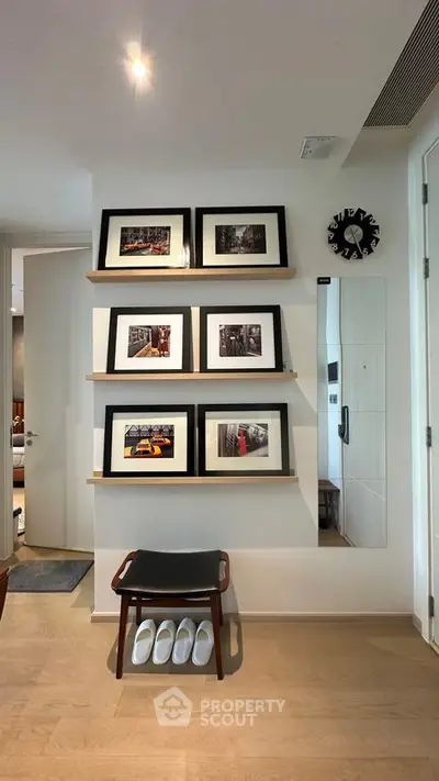 Stylish modern interior with framed art, wooden shelves, and sleek decor in a cozy living space.