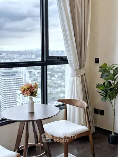 Chic high-rise apartment with stunning city view, elegant decor, and cozy seating area.