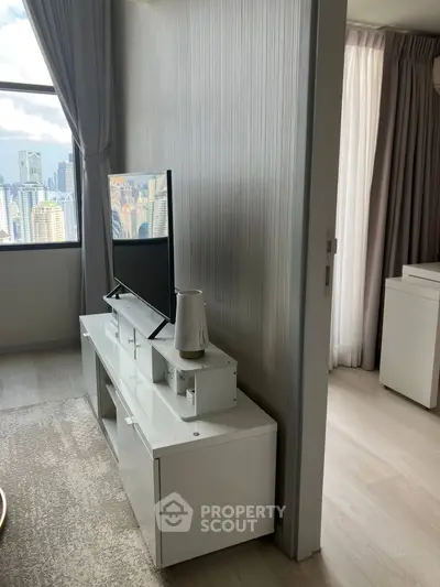 Modern living room with city view, sleek TV stand, and elegant decor.