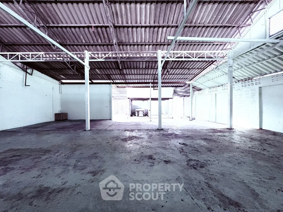 Spacious industrial warehouse with high ceilings and open floor plan, ideal for storage or manufacturing.