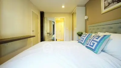 Spacious bedroom with modern decor and cozy ambiance, perfect for relaxation.