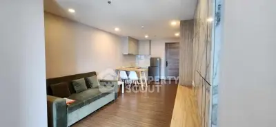 Modern living room with stylish furniture and open kitchen layout in a cozy apartment.