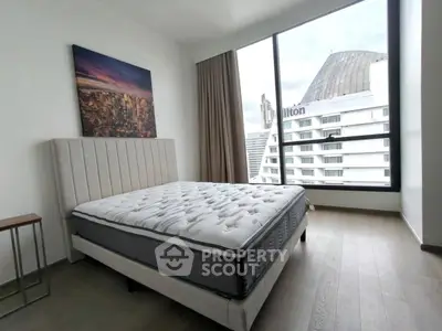 Modern bedroom with large window and city view, featuring a stylish bed and elegant decor.