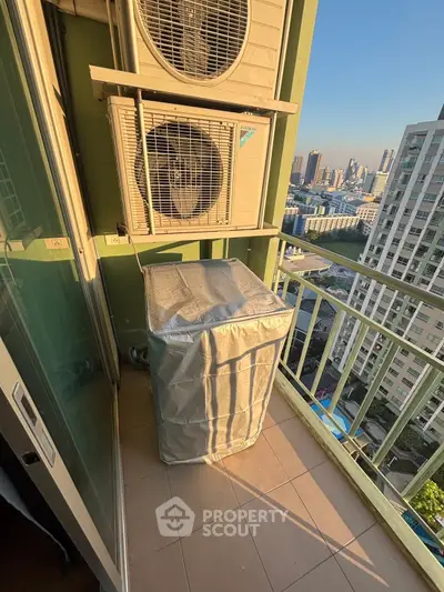 High-rise balcony with city view and air conditioning units.
