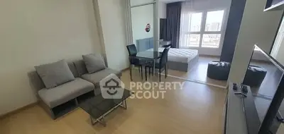 Modern open-plan living room with cozy sofa and dining area, featuring a view of the city skyline.