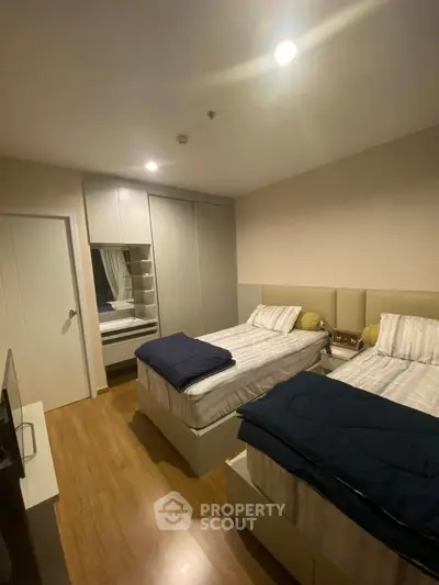 Cozy twin bedroom with modern decor and ample storage space