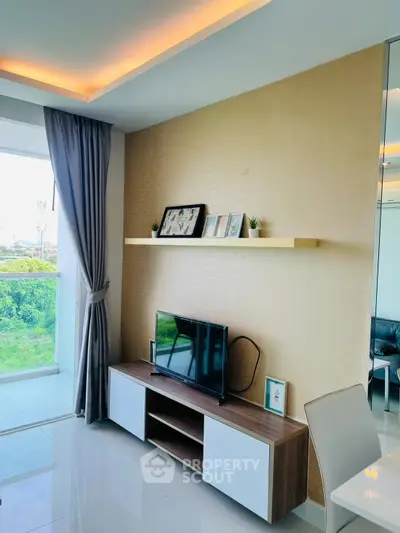 Modern living room with sleek TV stand and decorative shelf, large window with lush green view.