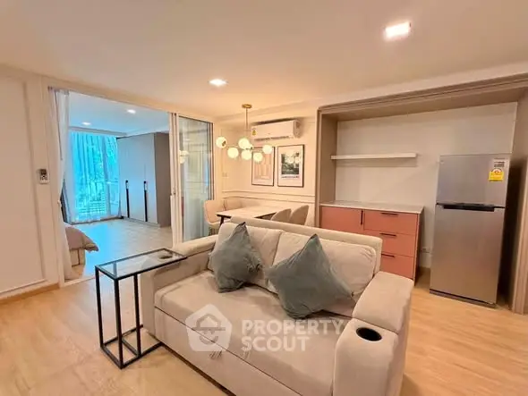 Modern living room with stylish decor and open layout leading to a cozy bedroom.