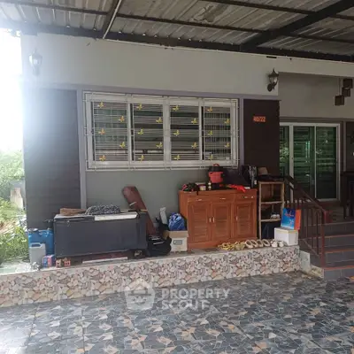 Charming residential exterior with tiled patio and covered entrance, perfect for outdoor relaxation.