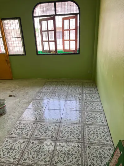 Spacious room with patterned tile flooring and large windows for natural light.