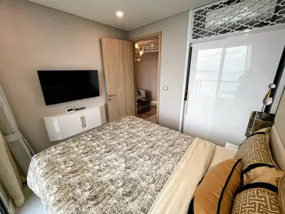 Modern bedroom with stylish decor and wall-mounted TV in a contemporary apartment.