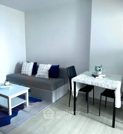 Modern living room with cozy sofa and dining area, featuring elegant decor and natural light.