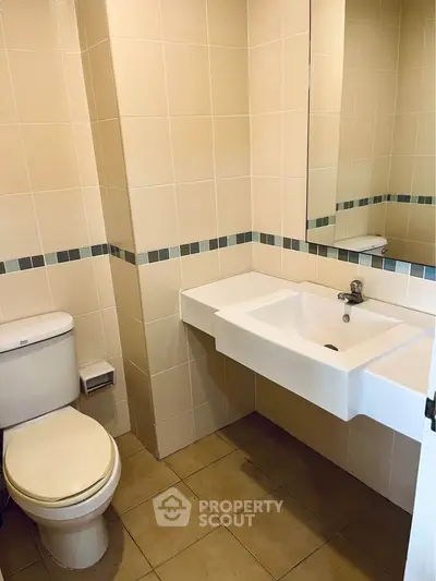 Modern bathroom with sleek sink and tiled walls, perfect for a contemporary home.