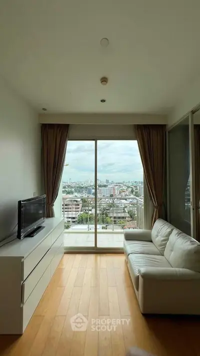 Modern living room with city view, sleek furniture, and large windows for natural light.