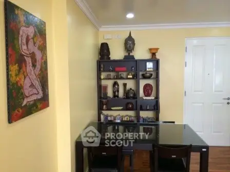 Charming dining area with elegant decor and glass-top table in cozy apartment.