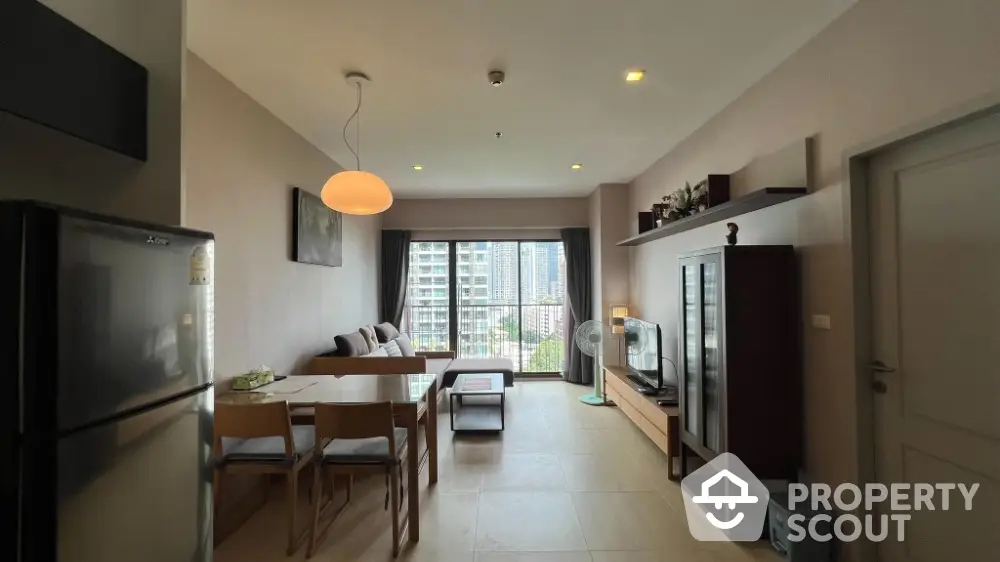 Modern living room with city view, stylish furniture, and natural light in a high-rise apartment.