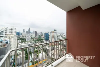 Stunning city view from high-rise apartment balcony with modern railing.