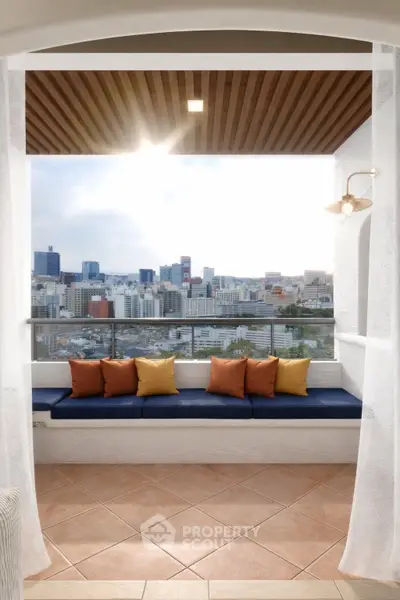 Stunning balcony with panoramic city view and cozy seating area, perfect for relaxation.