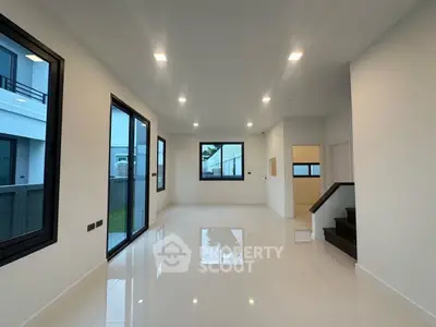 Spacious modern living room with large windows and sleek tile flooring
