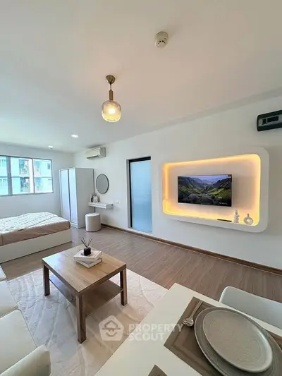 Modern studio apartment with stylish decor and wall-mounted TV