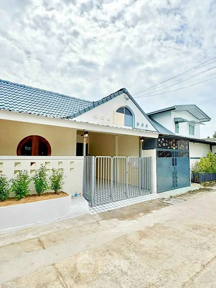 Charming single-story home with modern facade and gated entrance, perfect for family living.
