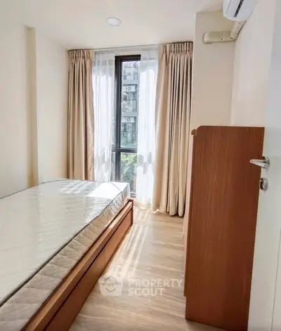 Cozy bedroom with natural light and modern furnishings in a stylish apartment.